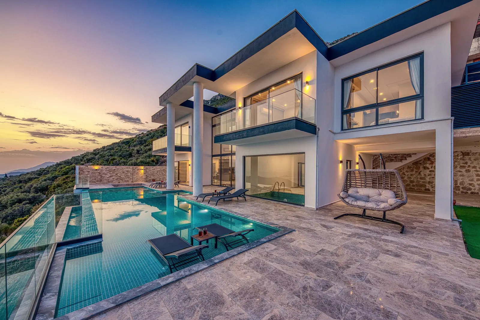 Gün batımında denize bakan sonsuzluk havuzlu villa terası